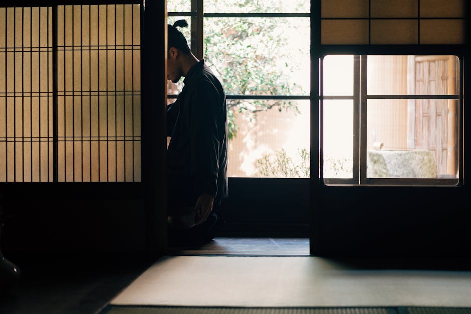 Person practicing zazen meditation in a traditional Japanese room with shoji screens